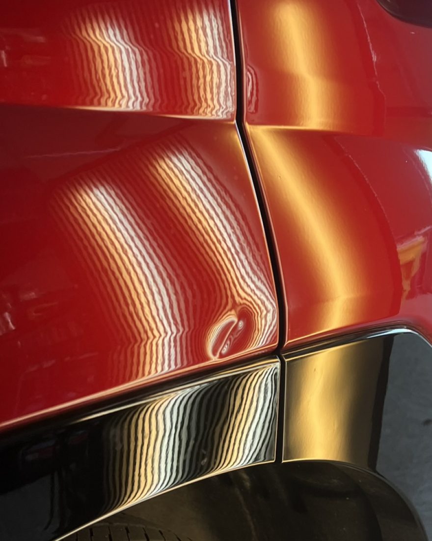 Before: the light board's stripes bend around a dent on the body line of a red Hyundai Santa Fe